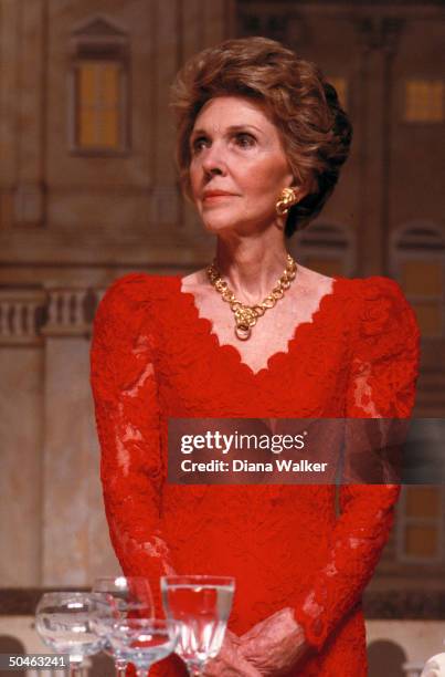 Nancy Reagan, decked out in red lace dress & gold earrings & necklace set, at president's dinner .
