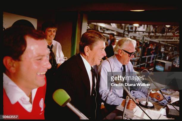 President Ronald Reagan sits in the broadcast booth with Chicago Cubs announcers Harry Caray and Steve Stone during a game with the Pittsburgh...