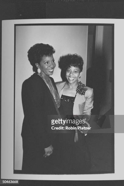 Singer Gladys Knight standing arm-in-arm w. Her daughter Kenya, whose holding a Canon auto-focus camera during Dionne Warwick's four-day benefit to...