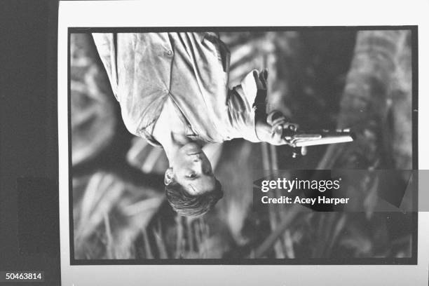 Actor Christian Bales in costume pointing an antique gun as young Jim Hawkins in TREASURE ISLAND, being made for Turner Network TV.