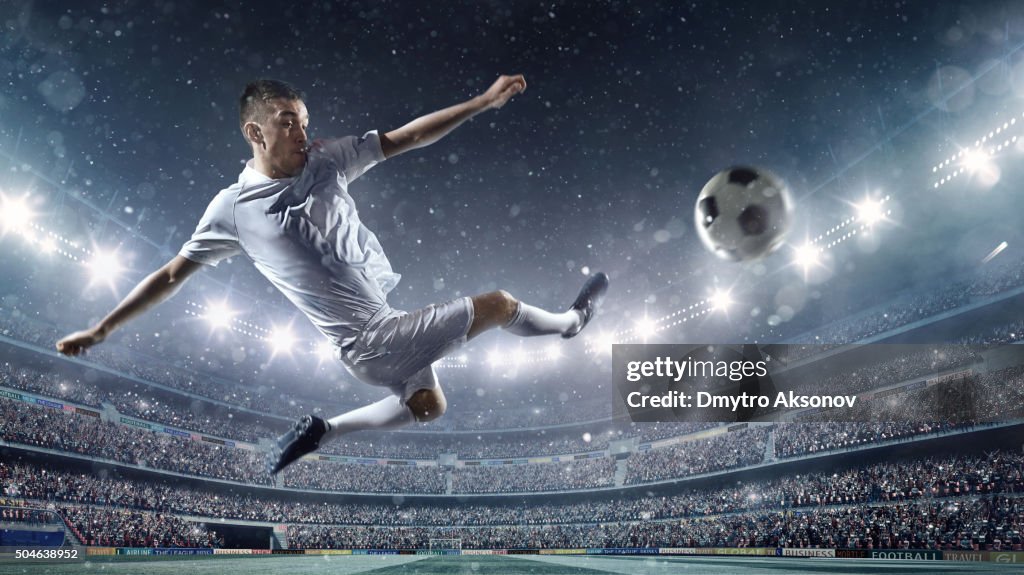 Soccer player kicking ball in stadium