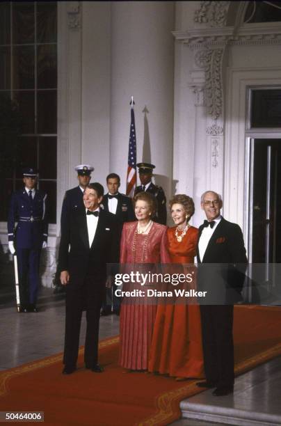 Pres. & Nancy Reagan w. British PM Margaret & Denis Thatcher, poised on red carpet, during State Dinner.