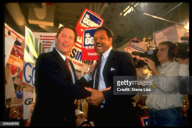 Dem. Rivals for pres. Nomination Rev. Jesse Jackson & Sen. Al Gore, gripping arms, showing solidarity, at State Dem. Conv.