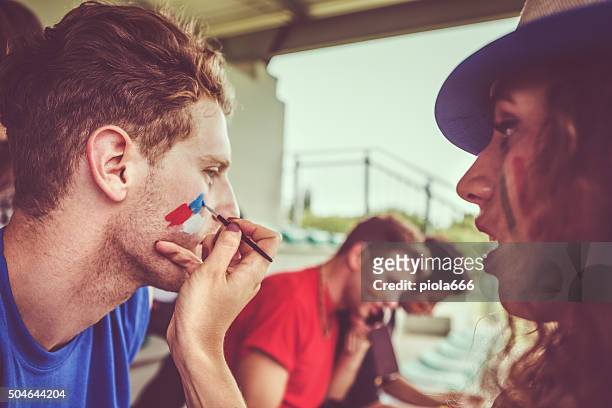 painting face to sport supporter - face paint stock pictures, royalty-free photos & images