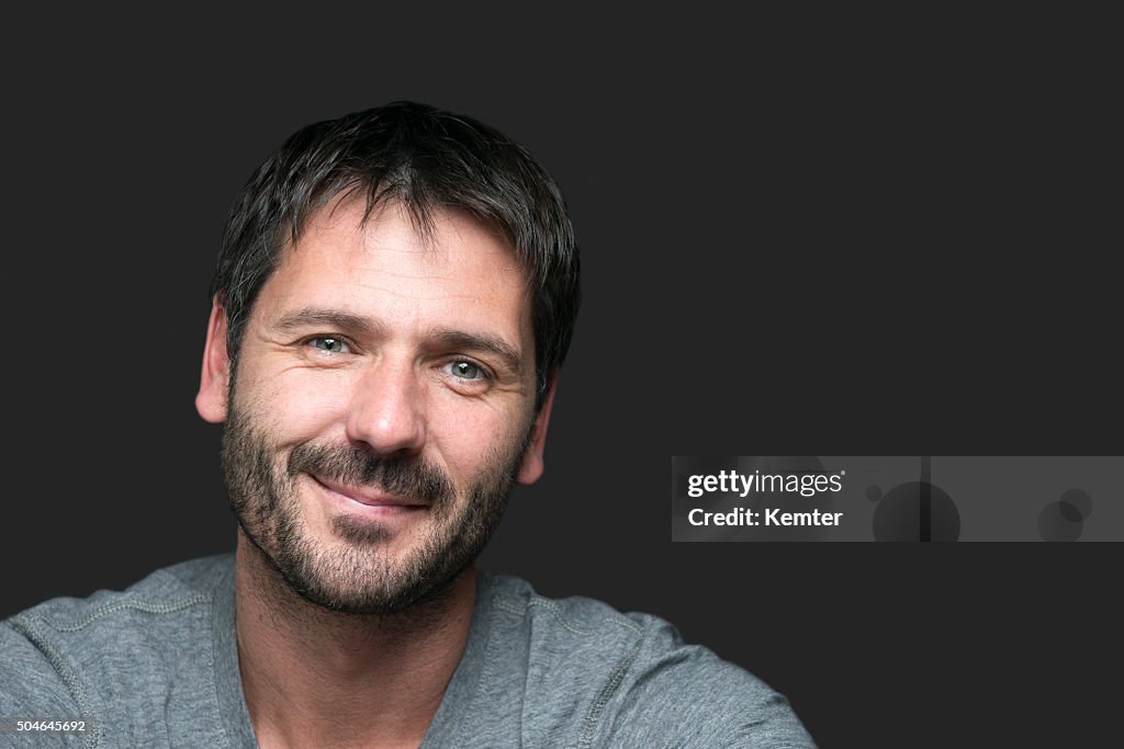 Charming smiling man portrait isolated on gray