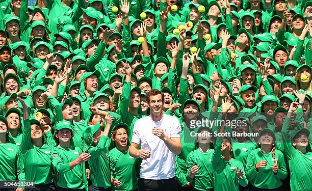 Andy Murray of Great Britain looks on as ballkids from Australia and overseas throw tennis balls in the air during the annual ballkid team photo...