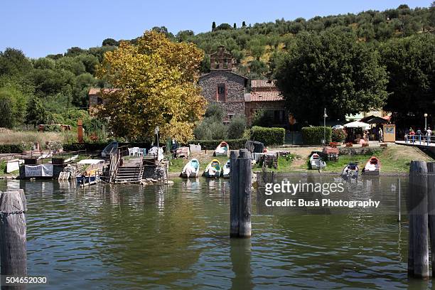 view from the water of a small port in the medieval town of lake trasimeno's isola maggiore, umbria, italy - lac trasimeno photos et images de collection