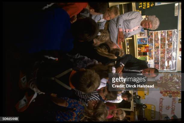 Pres. & Barbara Bush entertaining young audience, displaying artwork, imparting lesson in culture, paying classrm. Call, at elementary school in...