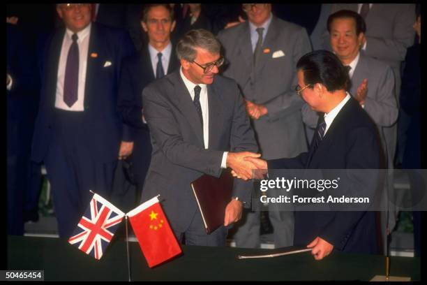 Li Peng & British PM Major shaking hands at Hong Kong agreement signing, framed by For. Mins. Qian Qichen & Hurd .