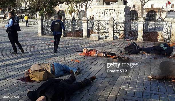 Graphic content / Police stand beside victims at the site of a blast in Istanbul's Sultanahmet district, the city's main tourist hub, on January 12,...