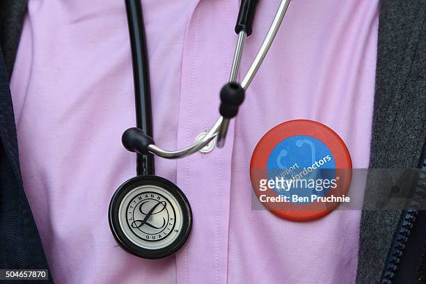 Junior doctor wears a stethoscope and a badge with the slogan "I support #juniordoctors" outside Guy's hospital as junior doctors stage a 24-hour...