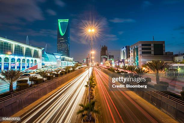 The Kingdom Tower, operated by Kingdom Holding Co., left, stands alongside the King Fahd highway, illuminated by the light trails of passing traffic,...