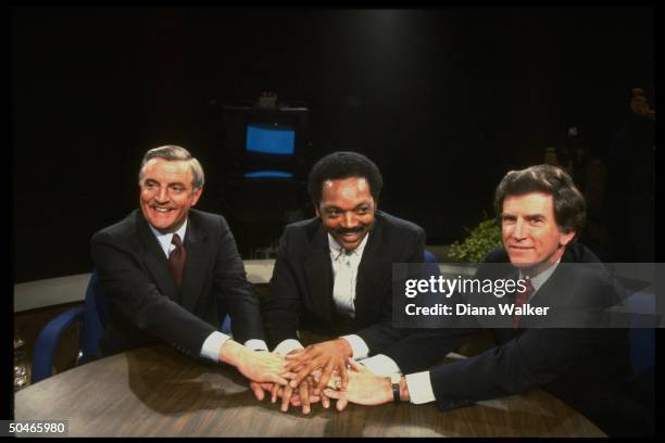 Dem. Pres. Rivals Gary Hart, Jesse Jackson & Walter Mondale piling linked hands, all smiles, in show of Dem. Solidarity, during debate.