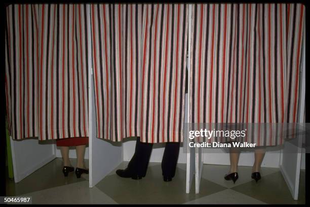 Pairs of Mondale family feet inside curtained booths as Eleanor, Walter & Joan vote in pres. Election.