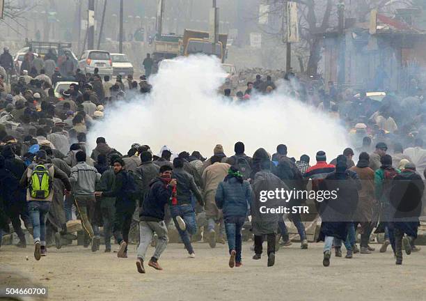 Kashmiri Muslims run as Indian police fire tear smoke shells during the funeral procession of suspected rebel commander, Sajad Ahmed Bhat on the...