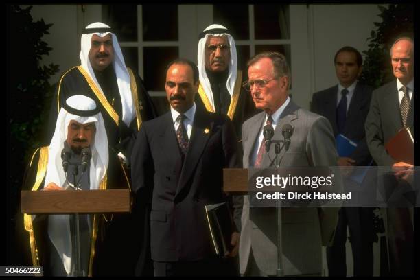 Pres. Bush & Kuwaiti Emir Jaber al-Ahmad Al Sabah , at twin podiums, framed by others incl. NSC 's Scowcroft , at WH portico ceremony.