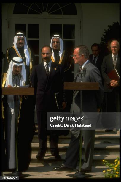 Pres. Bush & Kuwaiti Emir Jaber al-Ahmad Al Sabah , at twin podiums, framed by others incl. NSC 's Scowcroft , at WH portico ceremony.