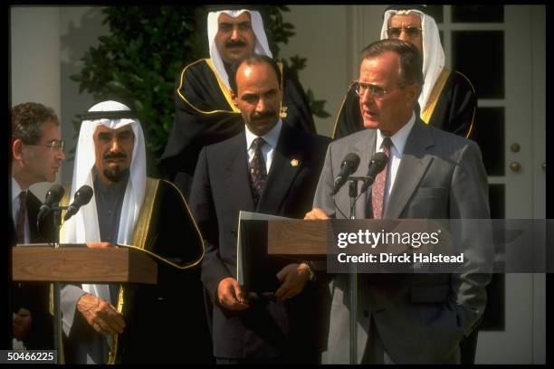 Pres. Bush & Kuwaiti Emir Jaber al-Ahmad Al Sabah , at twin podiums, framed by others incl. Interpreter , at WH portico ceremony.