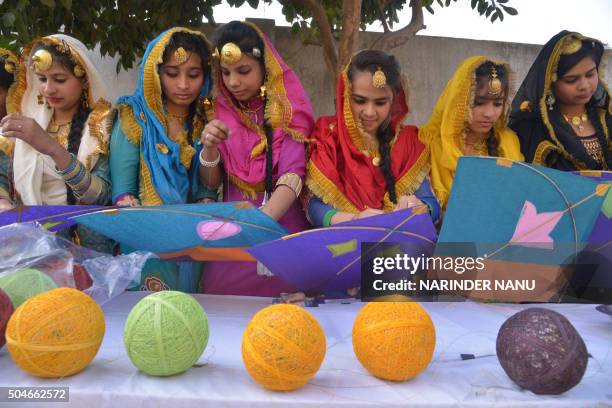 Indian school girls prepare to fly kites during celebrations on the eve of the Lohri festival in Amritsar on January 12, 2016. The Lohri harvest...