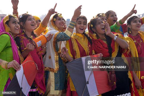 Indian school girls fly kites during celebrations on the eve of the Lohri festival in Amritsar on January 12, 2016. The Lohri harvest festival, which...