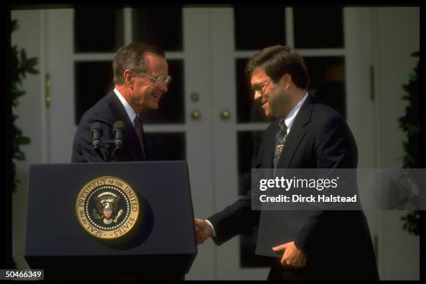 Dep. Atty. Gen. William Barr shaking hands w. Pres. Bush during announcement of his nomination to succeed Atty. Gen. Thornburgh, framed by WH portico.