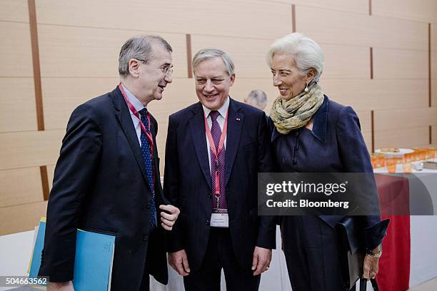 Francois Villeroy de Galhau, governor of the Bank of France, left, speaks with Christian Noyer, former governor of the Bank of France, centre, and...