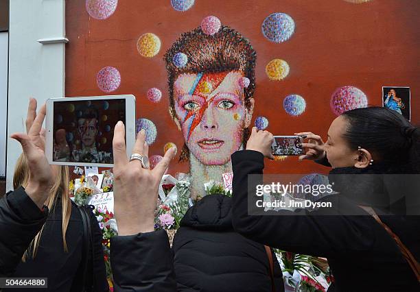 Fans and wellwishers gather to pay tribute to David Bowie at a mural in South London, on January 12, 2016 in London, England. British music and...