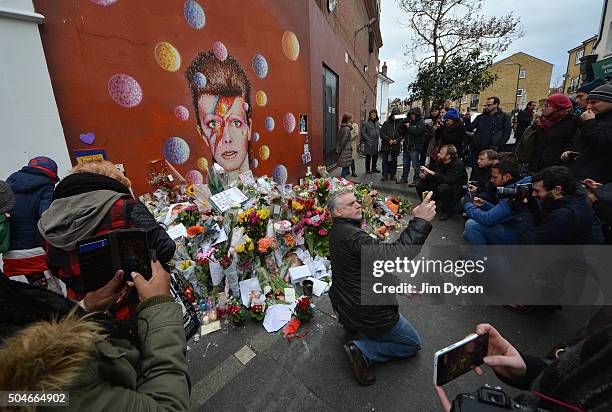 Fans and wellwishers gather to pay tribute to David Bowie at a mural in South London, on January 12, 2016 in London, England. British music and...