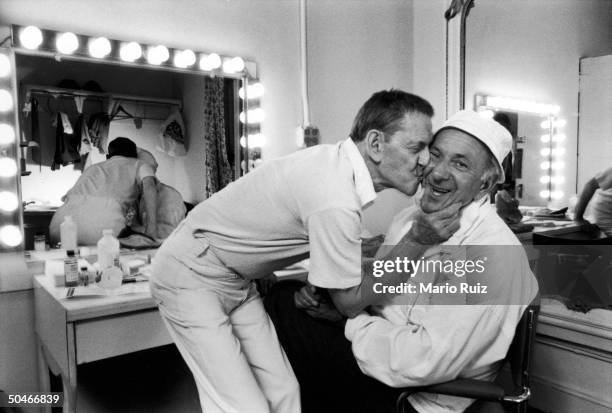 American actor Tony Randall plants a big kiss on the cheek of fellow actor Jack Klugman in their dressing room backstage before a one night benefit...