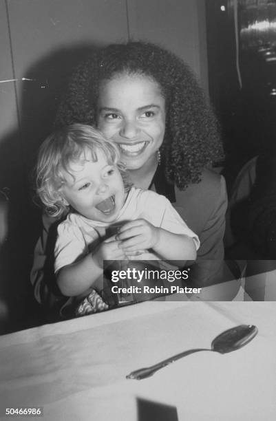 Actress Victoria Rowell, star of TV soap The Young and the Restless, holding young daughter Maya on her lap at premiere party for the newly restored...