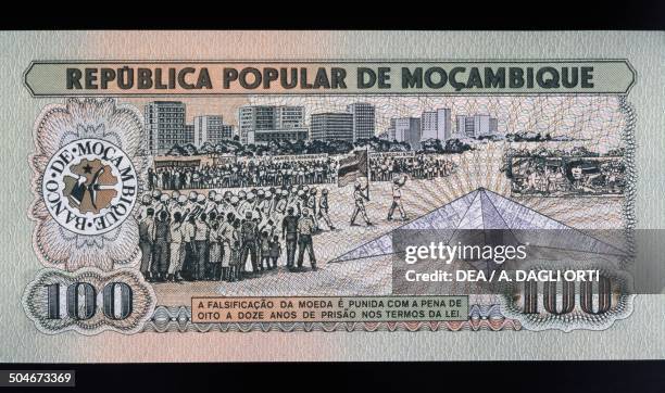 Meticais banknote obverse depicting a military parade. Mozambique, 20th century.