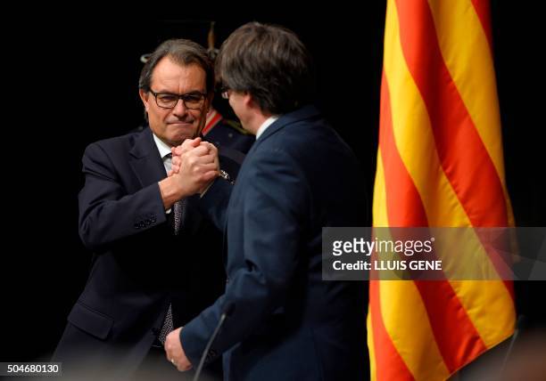 Outgoing President of the Catalan Government and leader of the Catalan Democratic Convergence Artur Mas shakes hands with new elected President of...