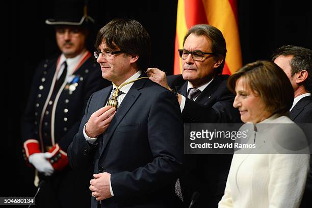 Former President of Catalonia Artur Mas puts the President of La Generalitat medal on the new president Carles Puigdemont at the Generalitat Palace,...