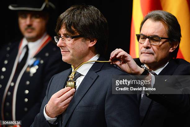 Former President of Catalonia Artur Mas puts the President of La Generalitat medal on the new president Carles Puigdemont at the Generalitat Palace,...