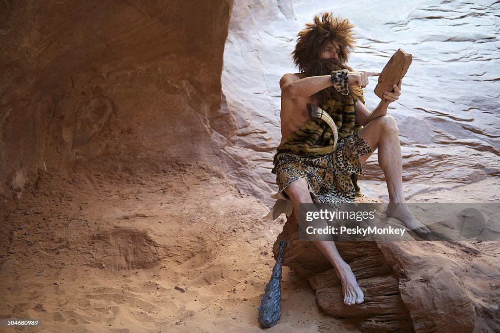 Caveman Sitting Outdoors Using Stone Tablet with Touchscreen