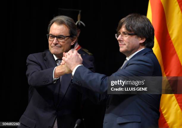 Outgoing President of the Catalan Government and leader of the Catalan Democratic Convergence Artur Mas shakes hands with new elected President of...