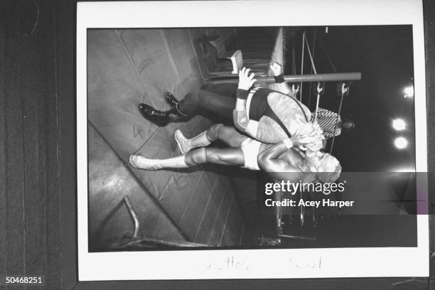 Wrestler Hulk Hogan grimacing as he applies pressure to the headlock he has on his opponent Sargeant Slaughter as they stand outside ring during...