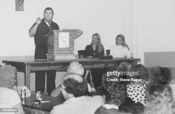 Ex-actor/self-proclaimed pres. Cand. Tom Laughlin speaking from podium as he addresses 120 voters in Teamsters Hall as his daughters Teresa & Kris...