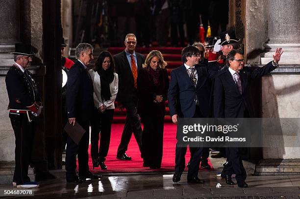 Former President of Catalonia Artur Mas acknowledges the crowd next to the new president Carles Puigdemont as they leave the Generalitat Palace,...