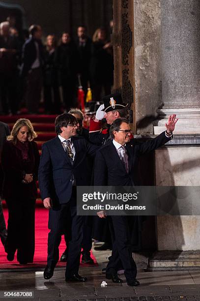 Former President of Catalonia Artur Mas acknowledges the crowd next to the new president Carles Puigdemont as they leave the Generalitat Palace,...