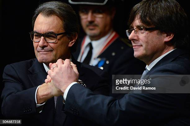 Former President of Catalonia Artur Mas and new president Carles Puigdemont shakes hands at the Generalitat Palace, house of the Catalan government,...
