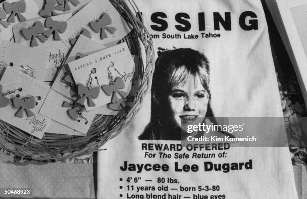 Closeup of 11-yr-old kidnap victim Jaycee Dugard's image & stats on t-shirt w. Jaycee keychains on sale at table manned by her parents Carl & Terry...