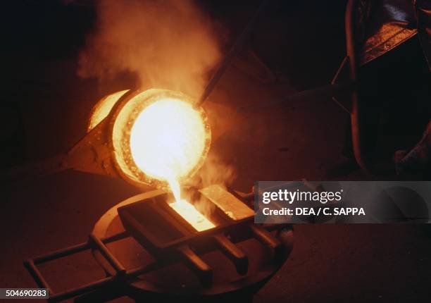 Molten gold poured into bar molds, gold mine of Poura, Burkina Faso.