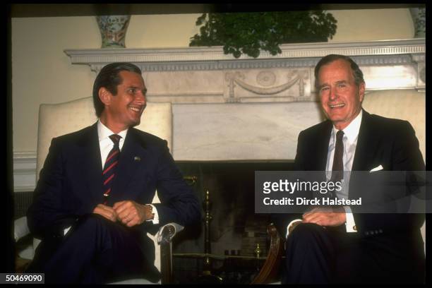 Pres. Bush mtg. W. Brazil's Pres. Fernando Collor de Mello, sitting, framed by WH Oval Office Swedish ivy plant-topped fireplace.