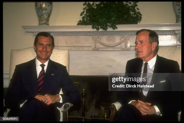 Pres. Bush mtg. W. Brazil's Pres. Fernando Collor de Mello, sitting, framed by WH Oval Office Swedish ivy plant-topped fireplace.