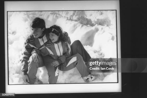 Olympic speedskater Bonnie Blair cuddling in the snow w. Her boyfriend, speedskater Dave Cruikshank, during a break in training outside hotel at...