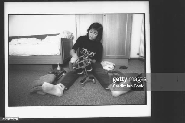 Olympic speedskater Bonnie Blair sitting on floor in hotel room, sharpening her speedskates during training at Klobenstein in the Italian mountains.