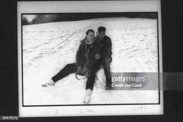 Blobsled teammates , ex-skier Randy Will & football star Herschel Walker, sitting together on small sled on practice slope as they relax from...