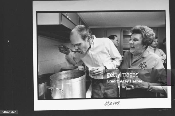 James Carville, pol. Consultant for Dem. Pres. Cand. Bill Clinton, tasting a spoonful of soup from large pot on stove while his mom Lucille laughs...