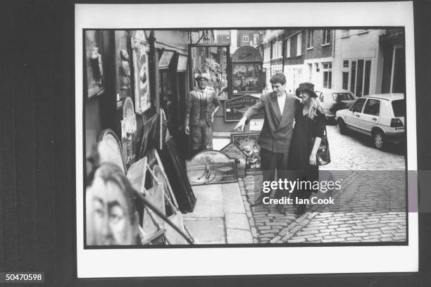 Actress Joely Richardson, 8-mos. Pregnant, w. Her film producer husband Tim Bevan, looking over a display of antiques outside small store.